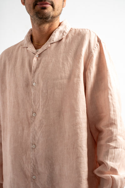Man wearing a light pink shirt against a white background