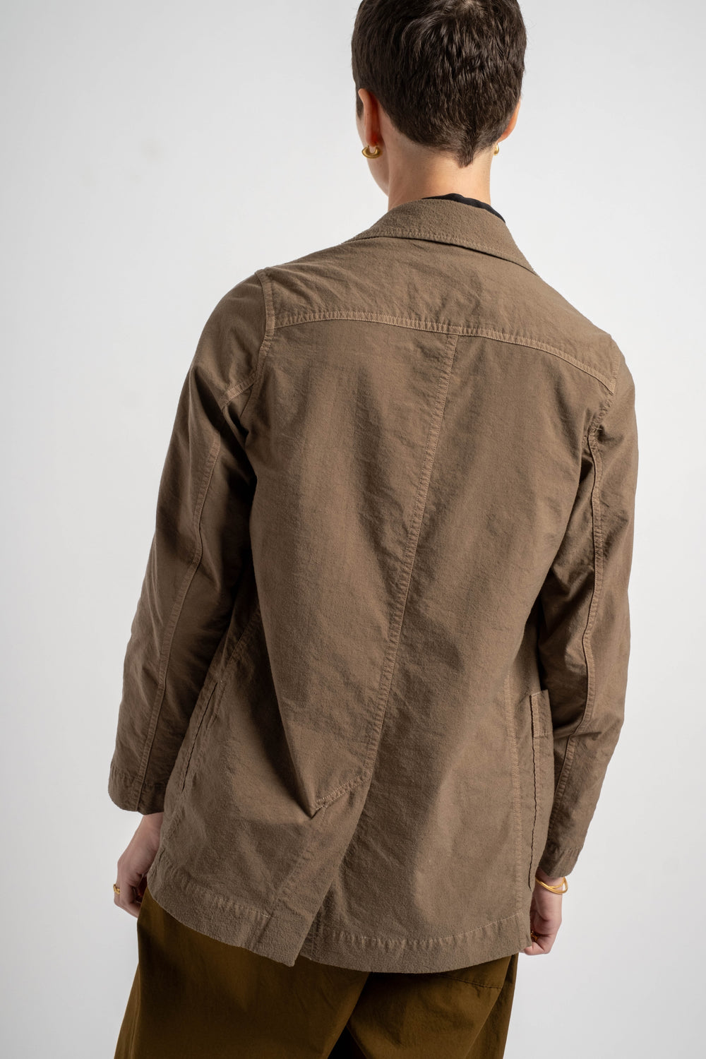 Person wearing a brown jacket on a white background