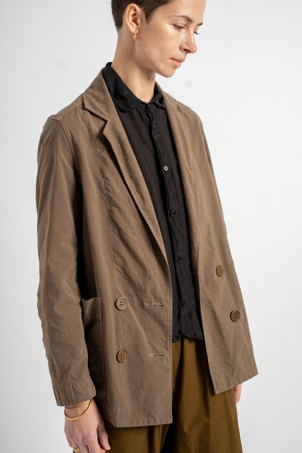 Person wearing a brown coat over a black shirt on a white background
