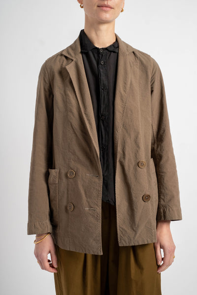 Person wearing a brown jacket over a black shirt on a white background