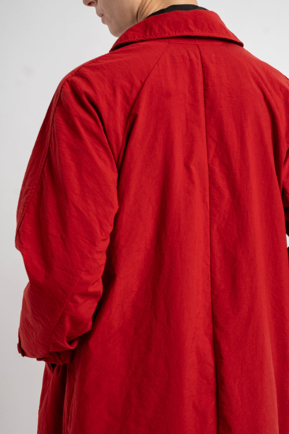 Red coat worn by a person on a white background