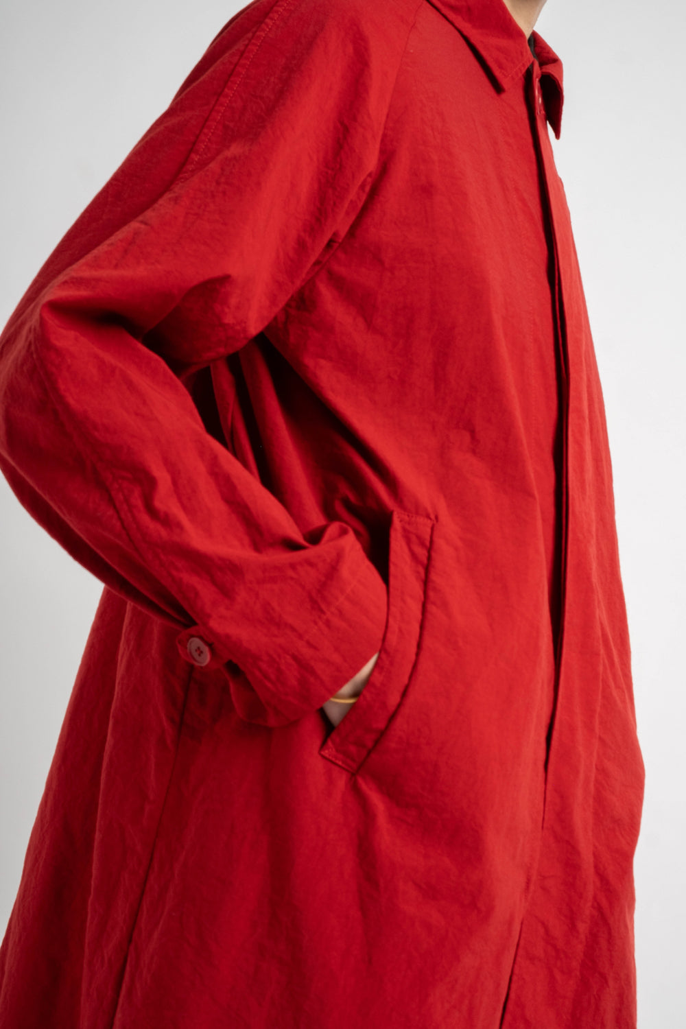 Red coat worn by a person on a white background