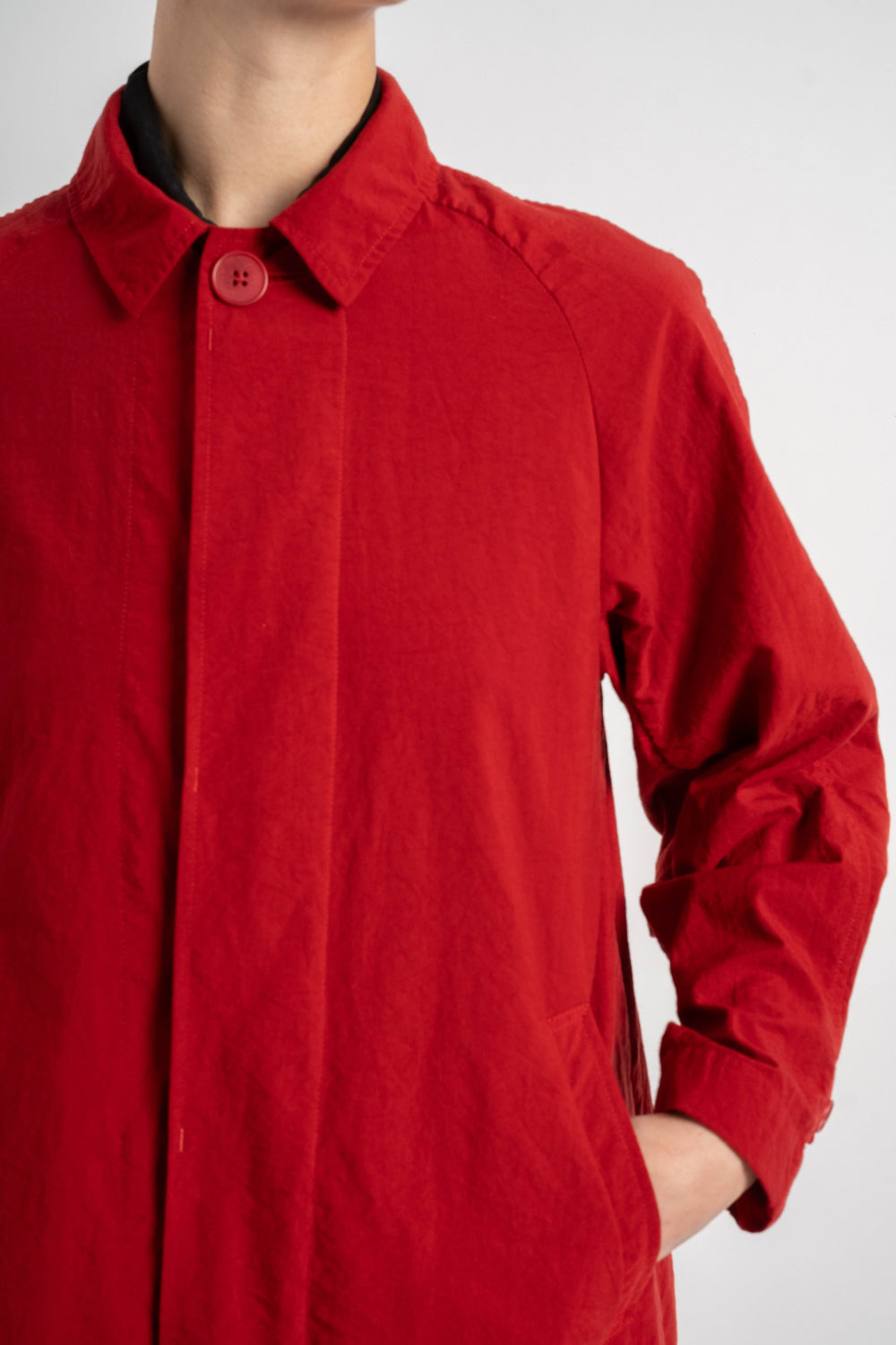 Red coat worn by a person on a white background