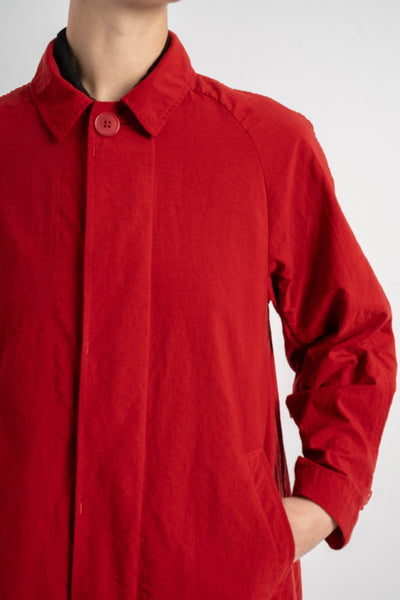 Red coat worn by a person on a white background