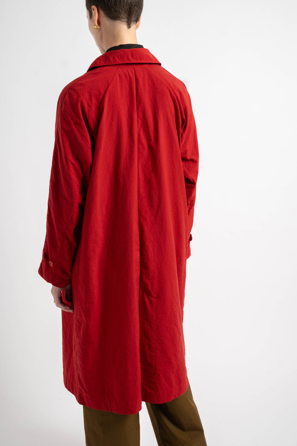 Red coat worn by a person on a white background