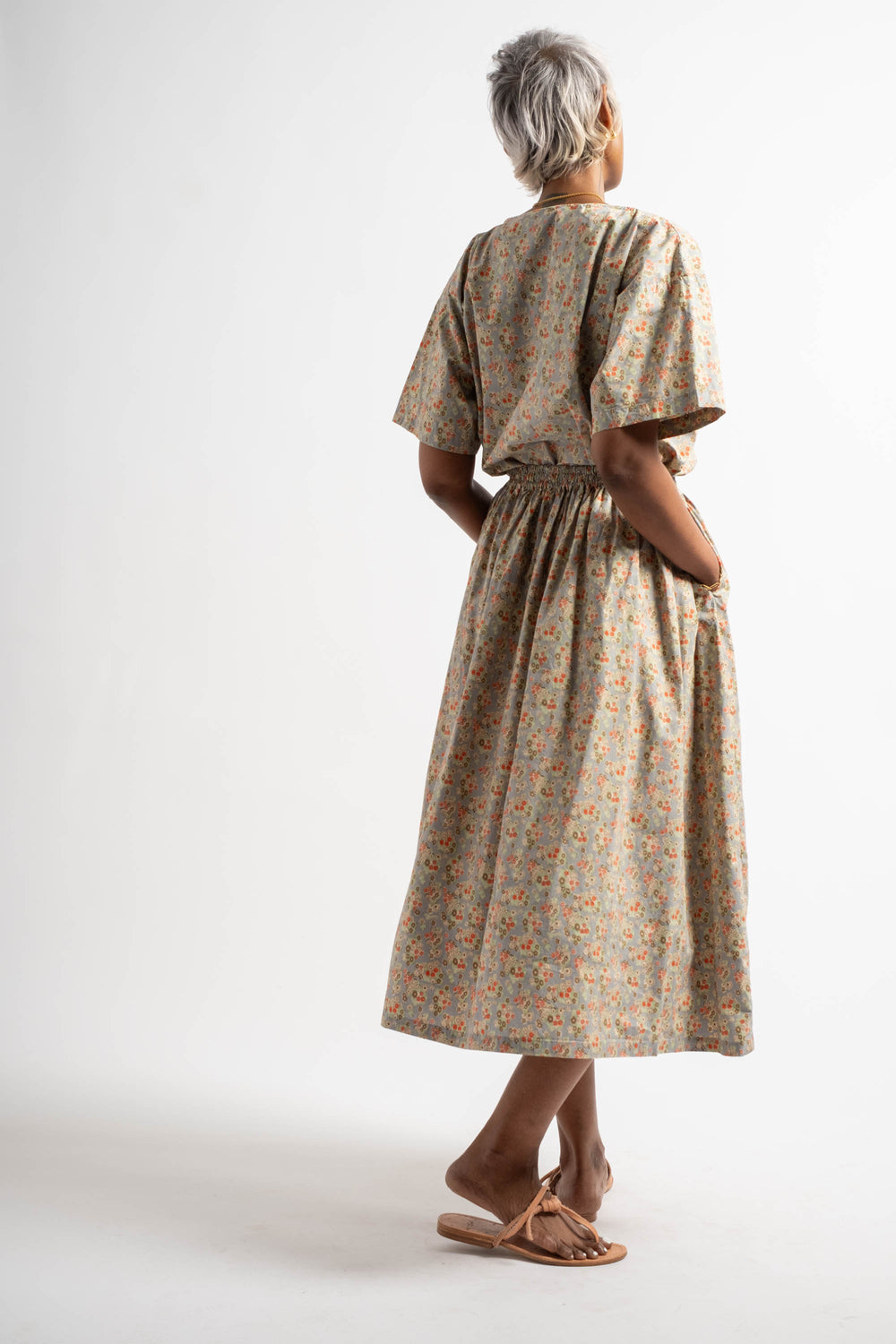 Woman wearing a patterned dress on a white background