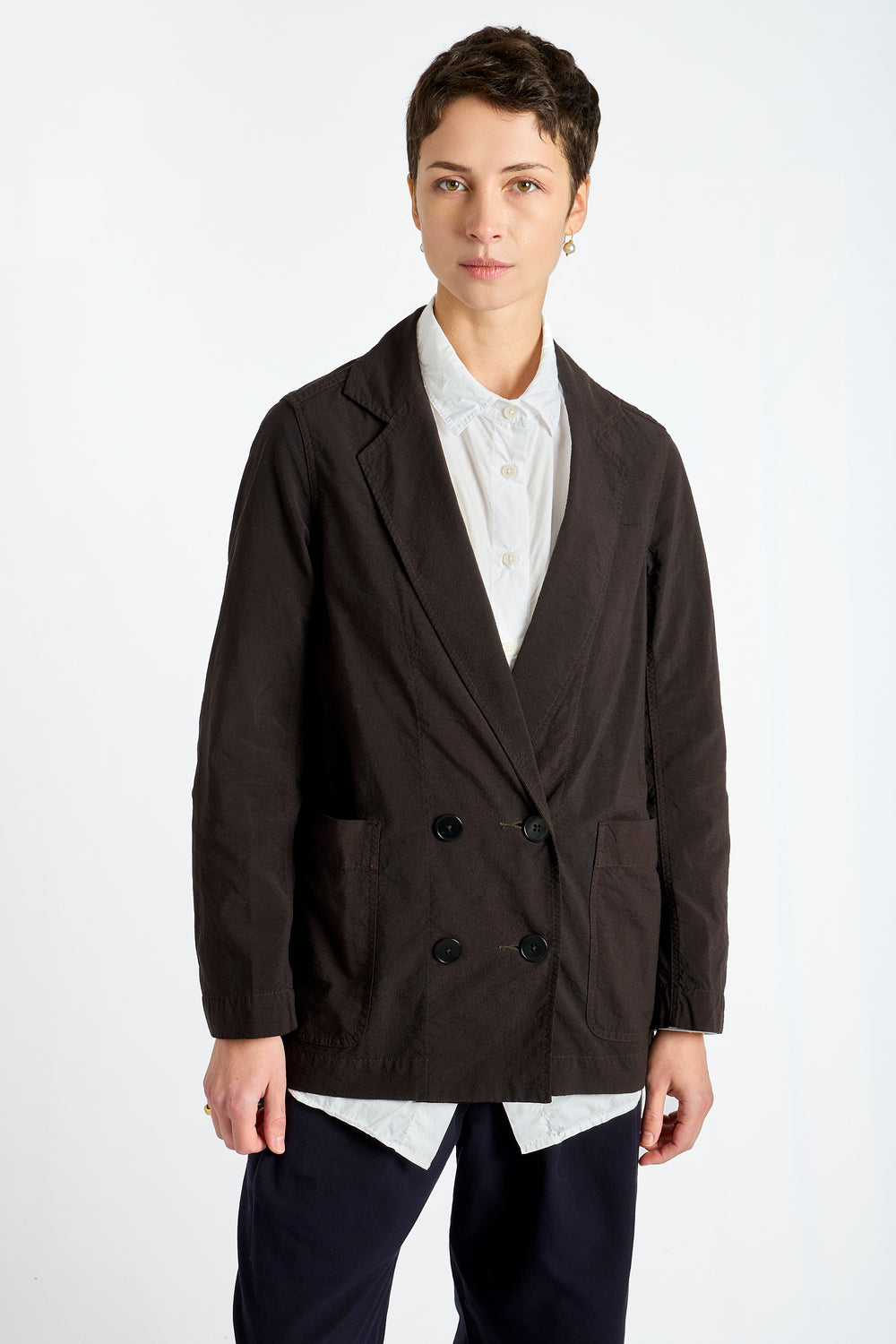 Person wearing a dark brown blazer over a white shirt on a white background