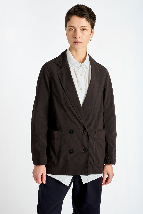 Person wearing a dark brown blazer over a white shirt on a white background